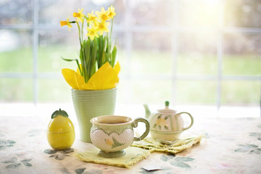 yellow flowers on a table with tea and sugar